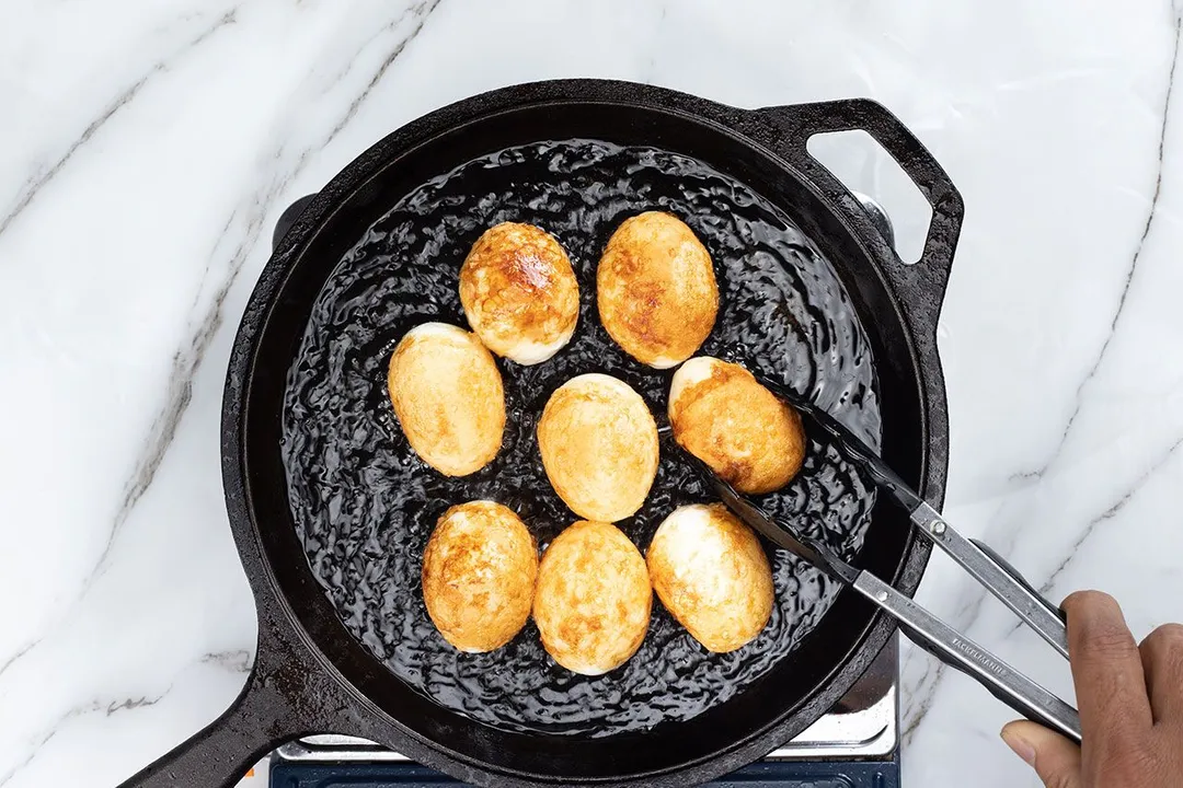 frying 8 boiled eggs in a skillet