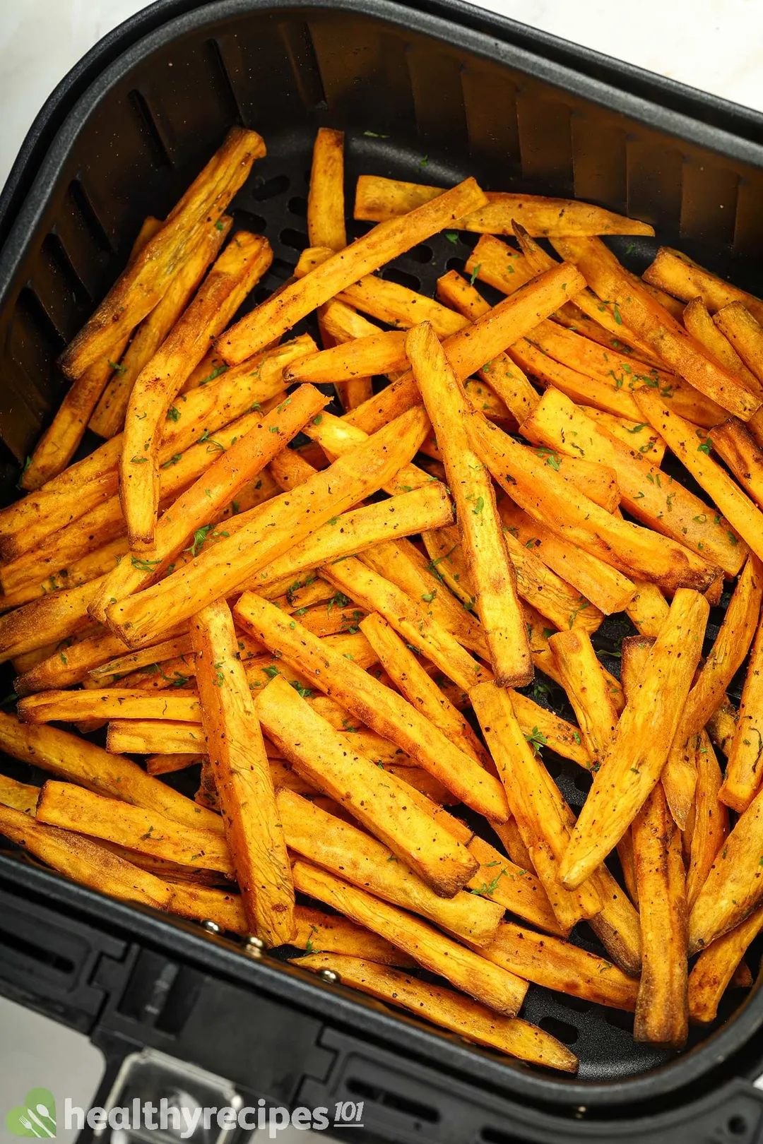 cooked sweet potato sticks in an air fryer basket