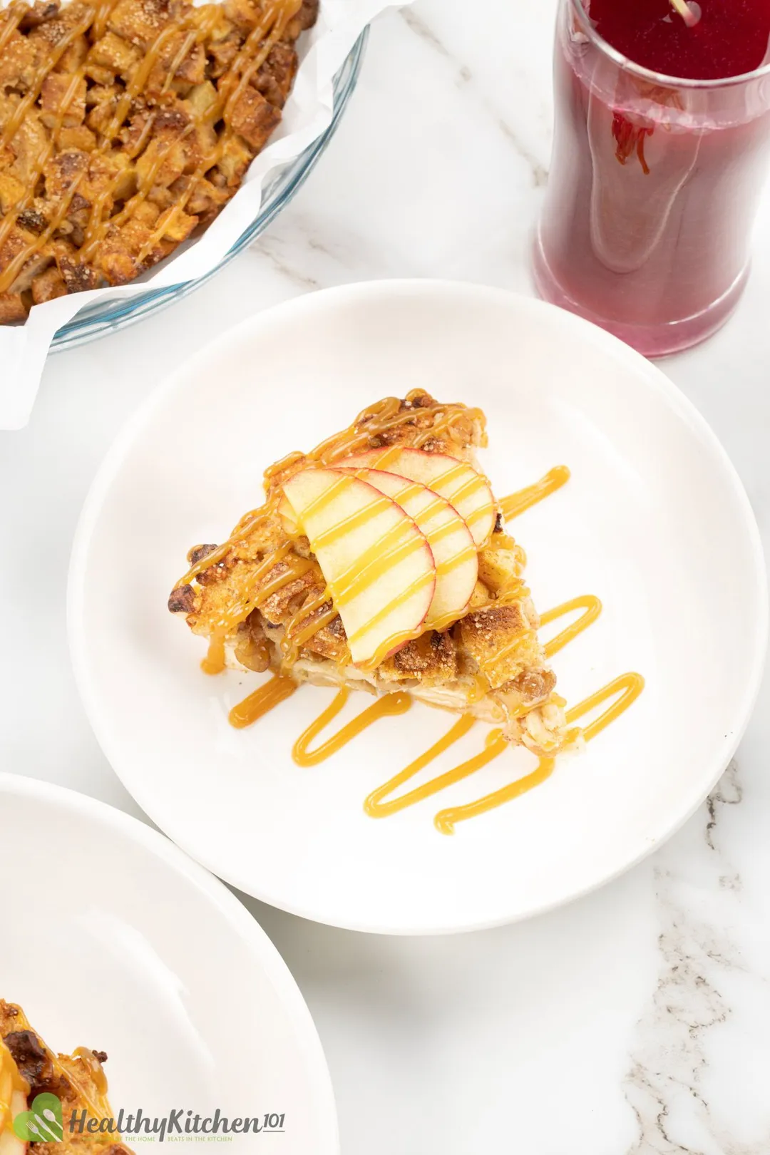 a plate of bread pudding with a glass of blue berry juice and a bowl of budding