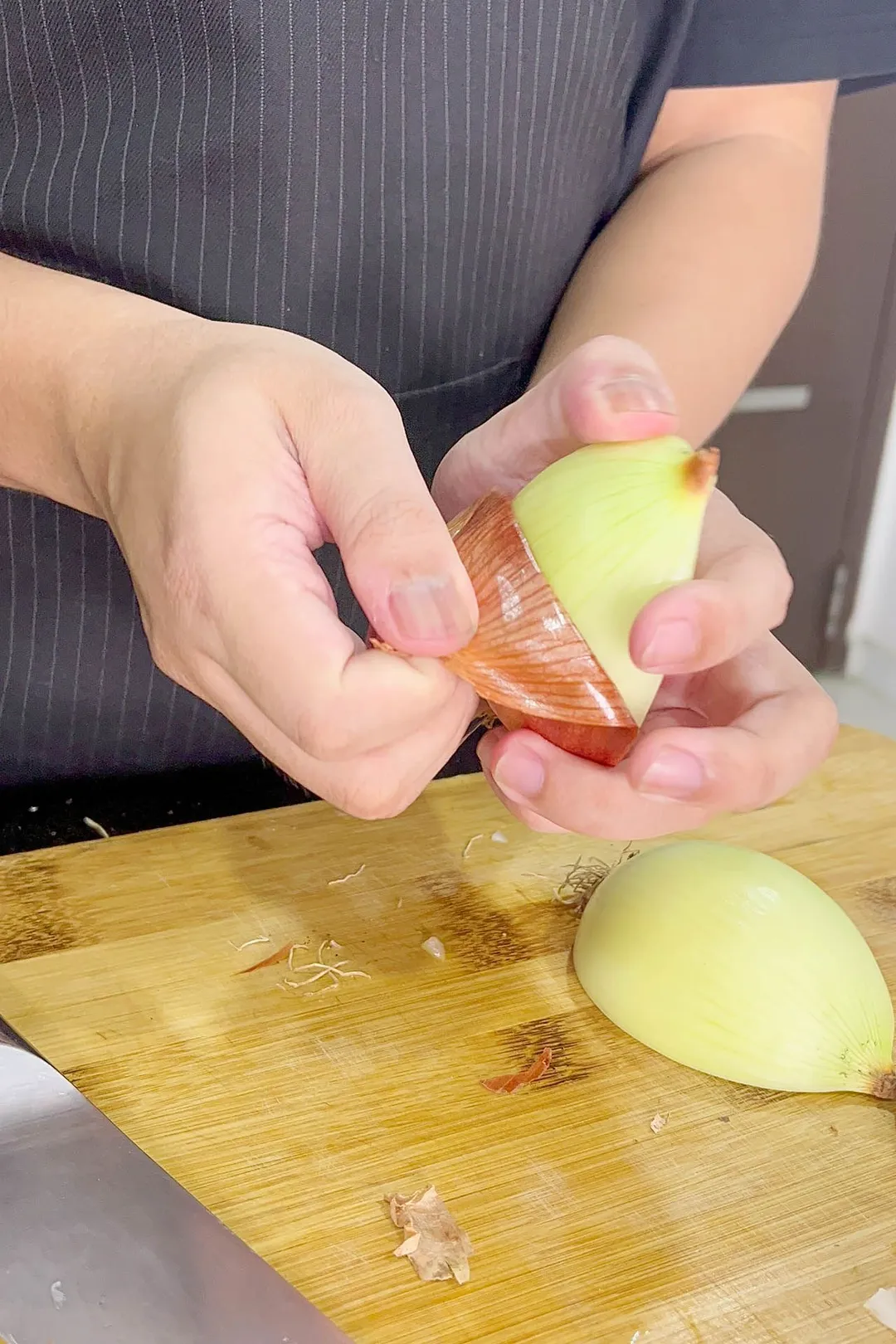 two hand holding and peeling half onion