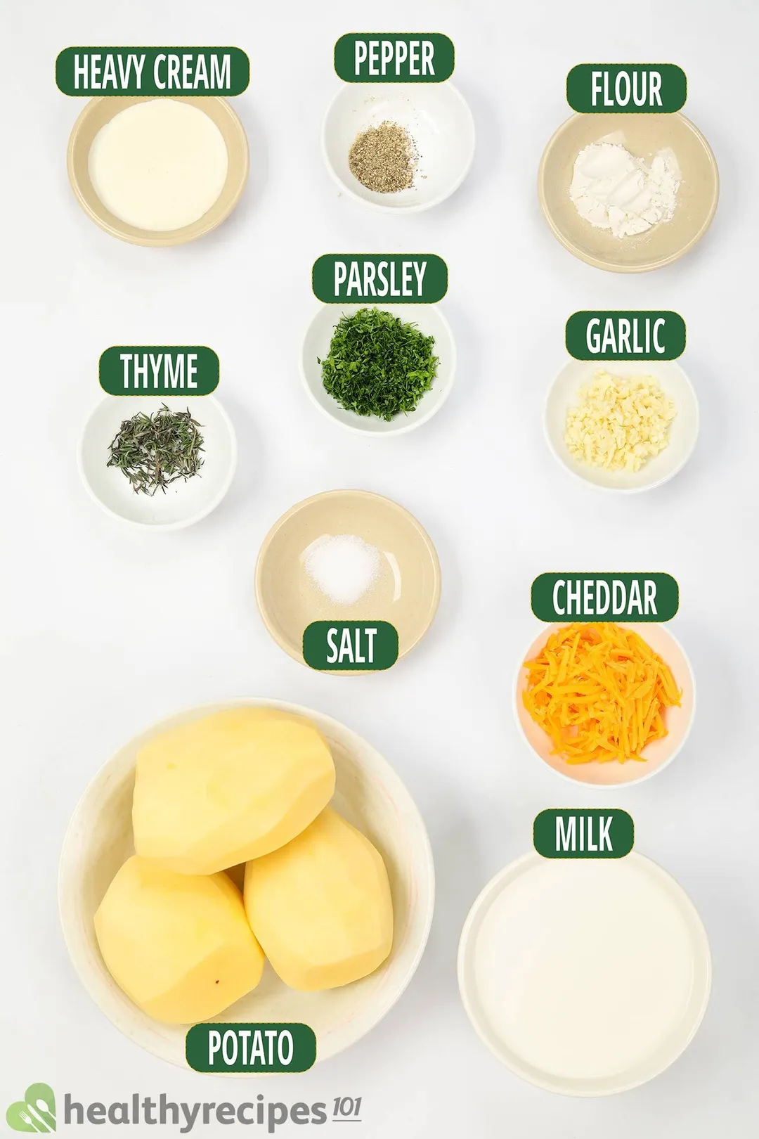 Ingredients for potato gratin, including peeled potatoes, shredded cheddar cheese, milk, flour, chopped parsley, and others.