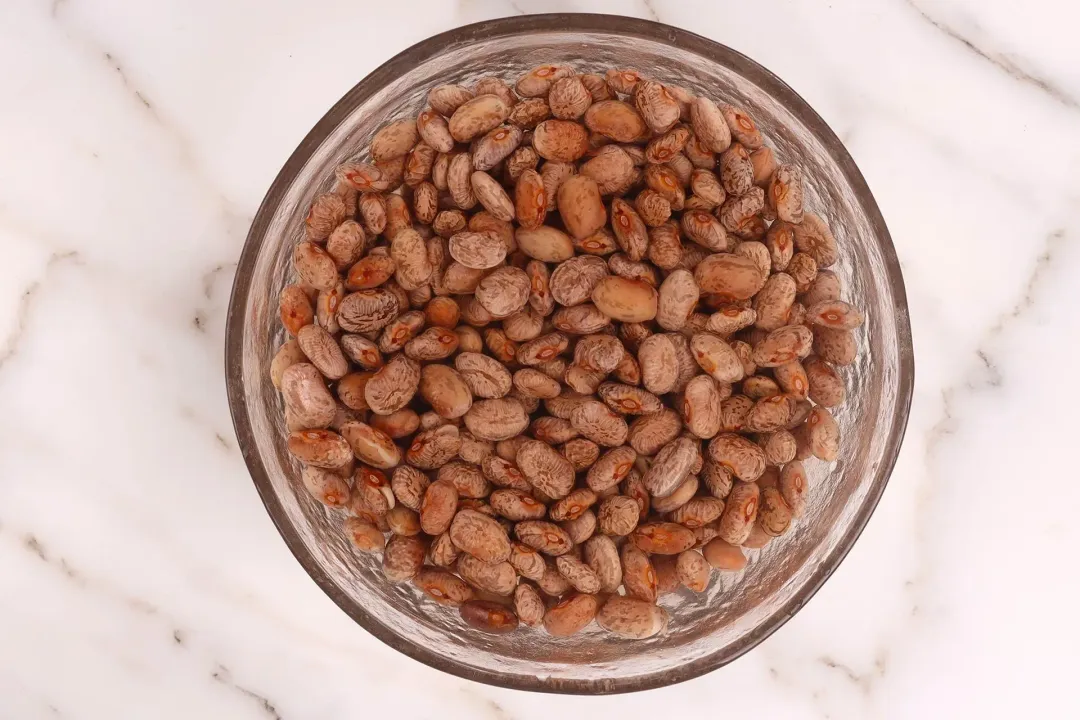 Soak the pinto beans in hot water for a few hours