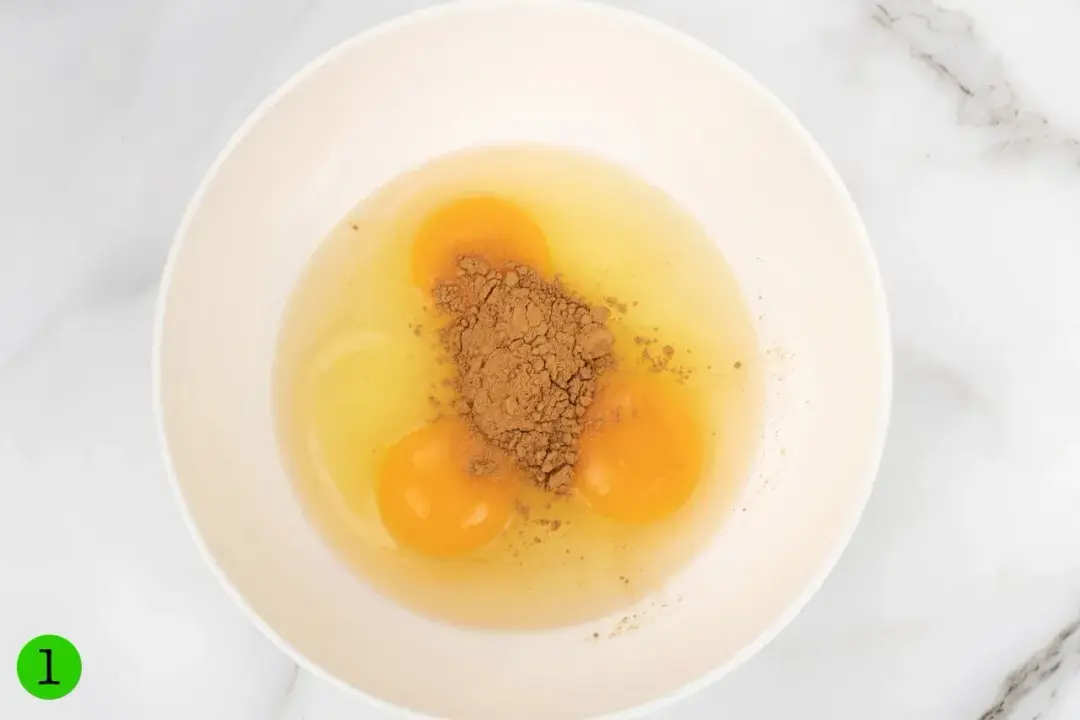 Cracked eggs with spices on top in a bowl