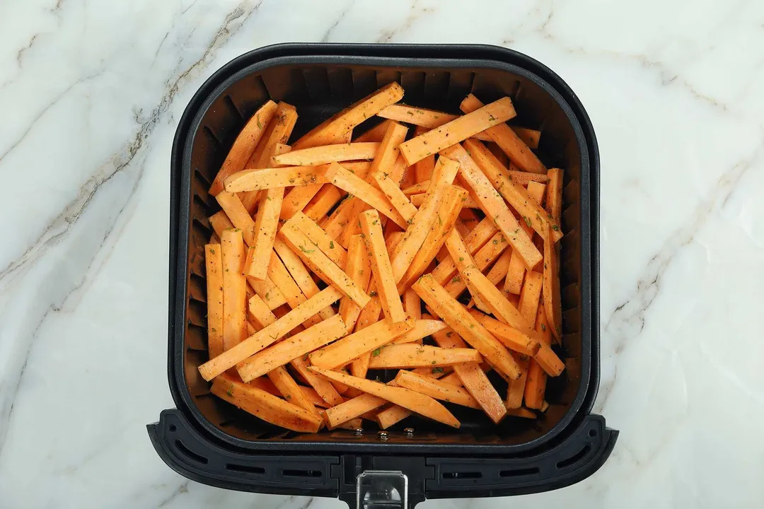 sweet potato sticks in an air fryer basket