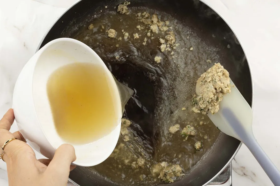 A hand distributing some oil into a hot pan.