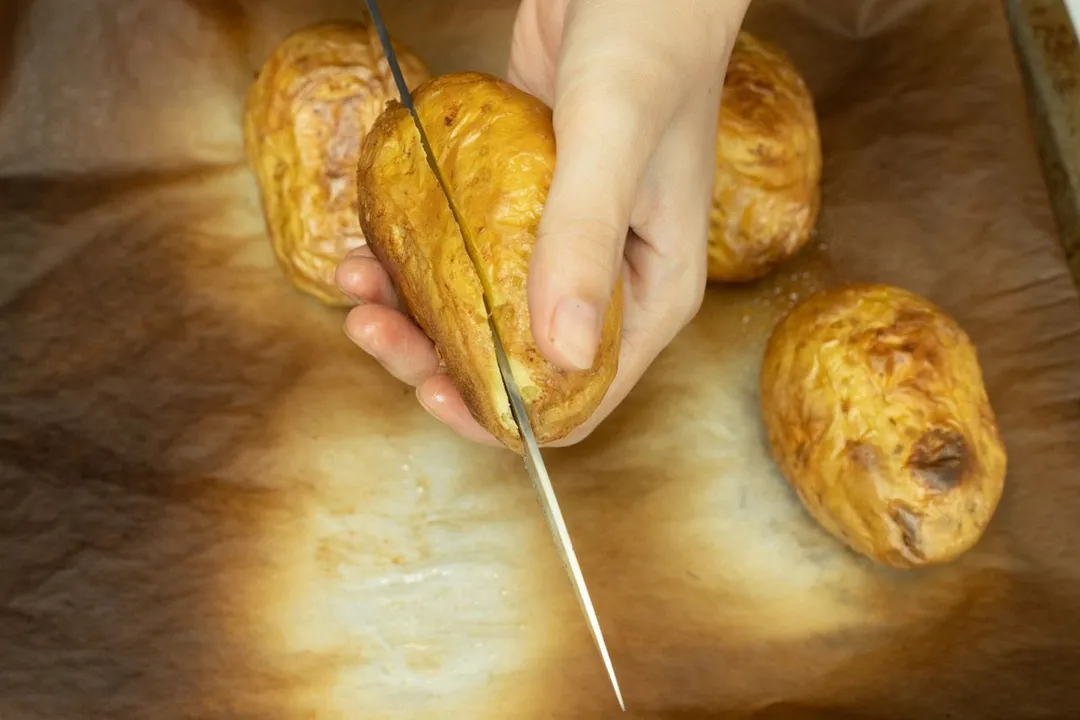 cutting the top of a baked potato