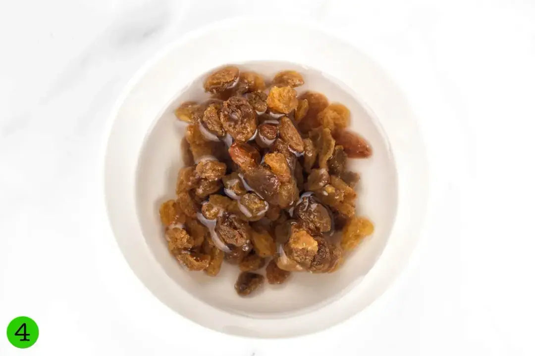 A small bowl of raisins soaked in water