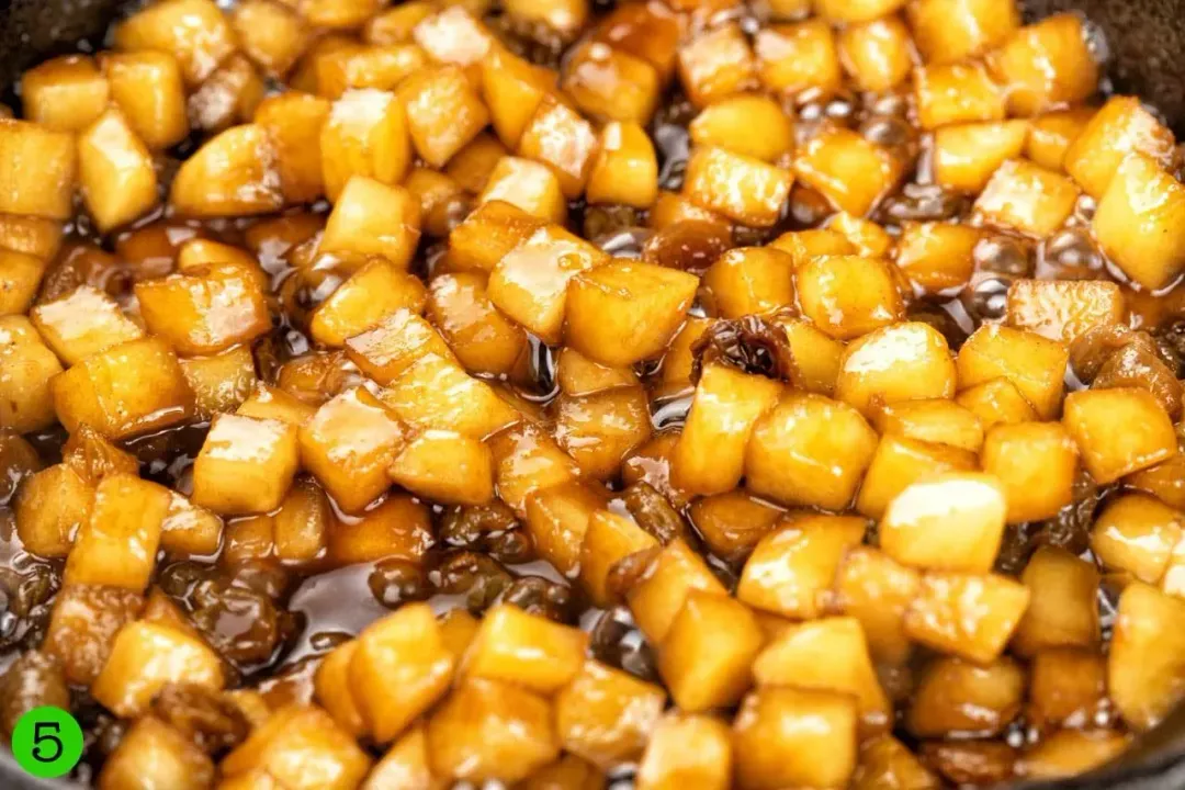 Cubes of apple drenched in caramel sauce bubbling in a pan