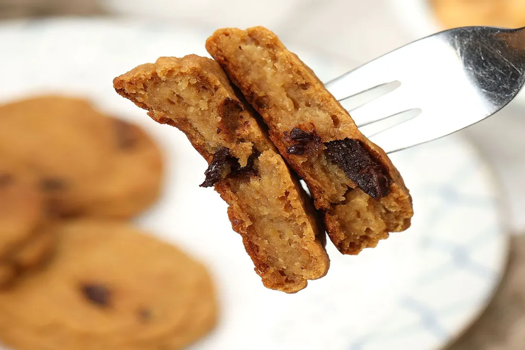 A fork piercing into two halves of a chickpea cookie.