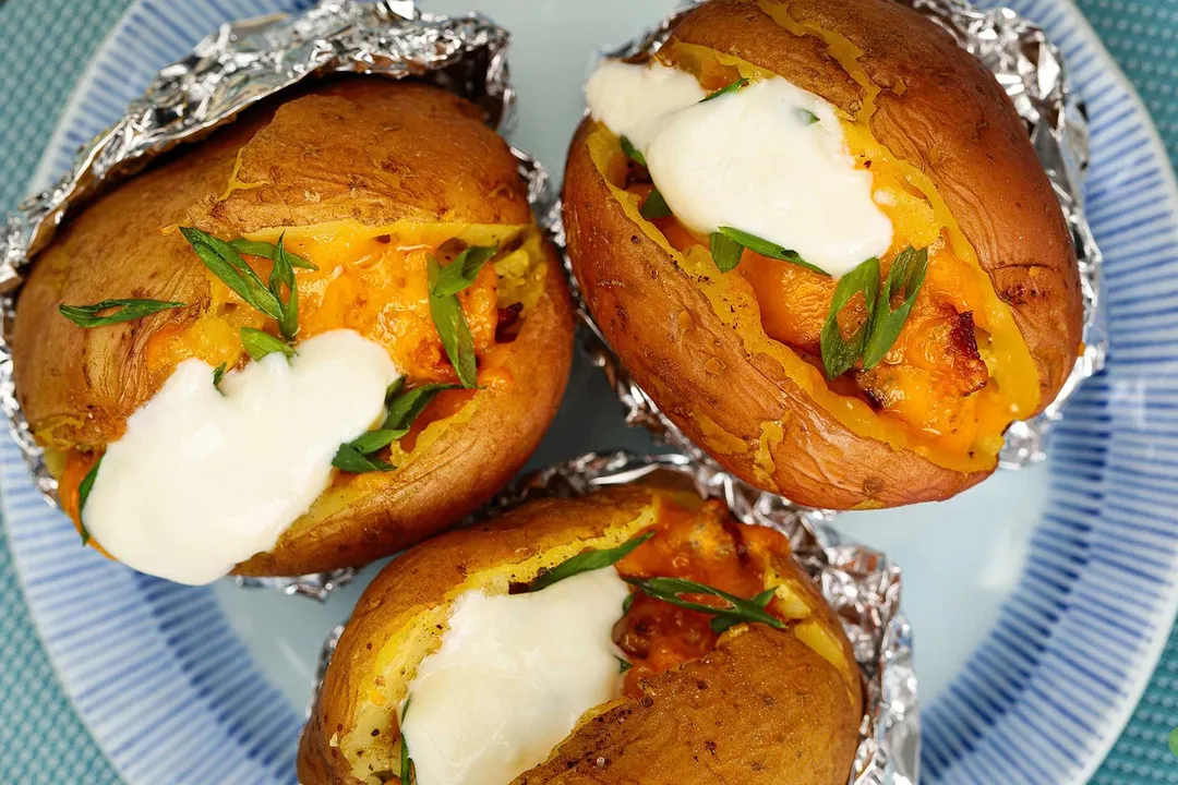 three baked potatoes on a plate