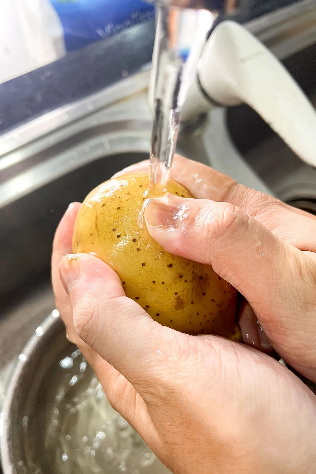 two hand holding and wash a potato