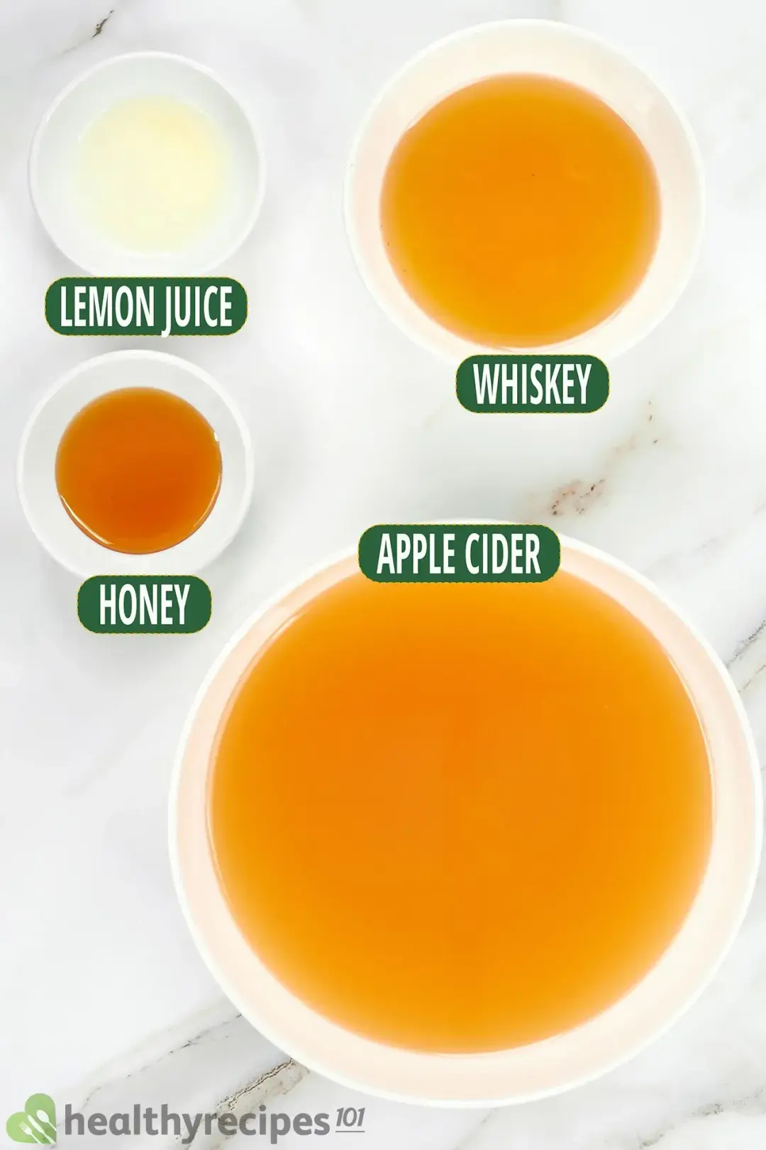 Ingredients in separate bowls: aplpe cider, whiskey, lemon juice, and honey