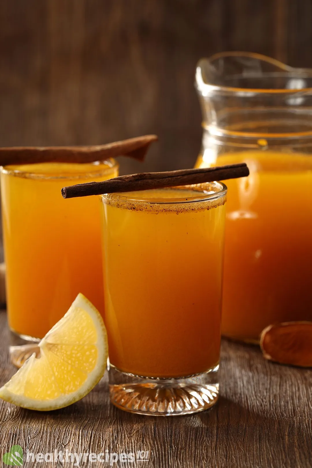 two glasses and a pitcher of yellow liquid