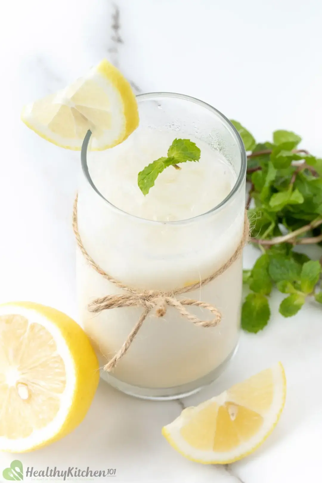 A glass of iced milk and lemon juice, garnished with lemons and mints and tied with a kitchen string
