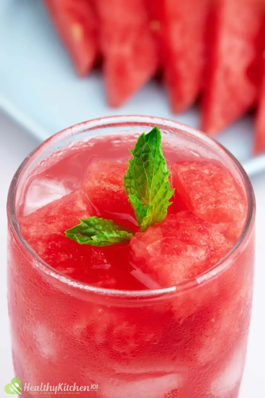 A close-up shot of a glass of watermelon juice and lemon from above with mint leaves on top for decoration