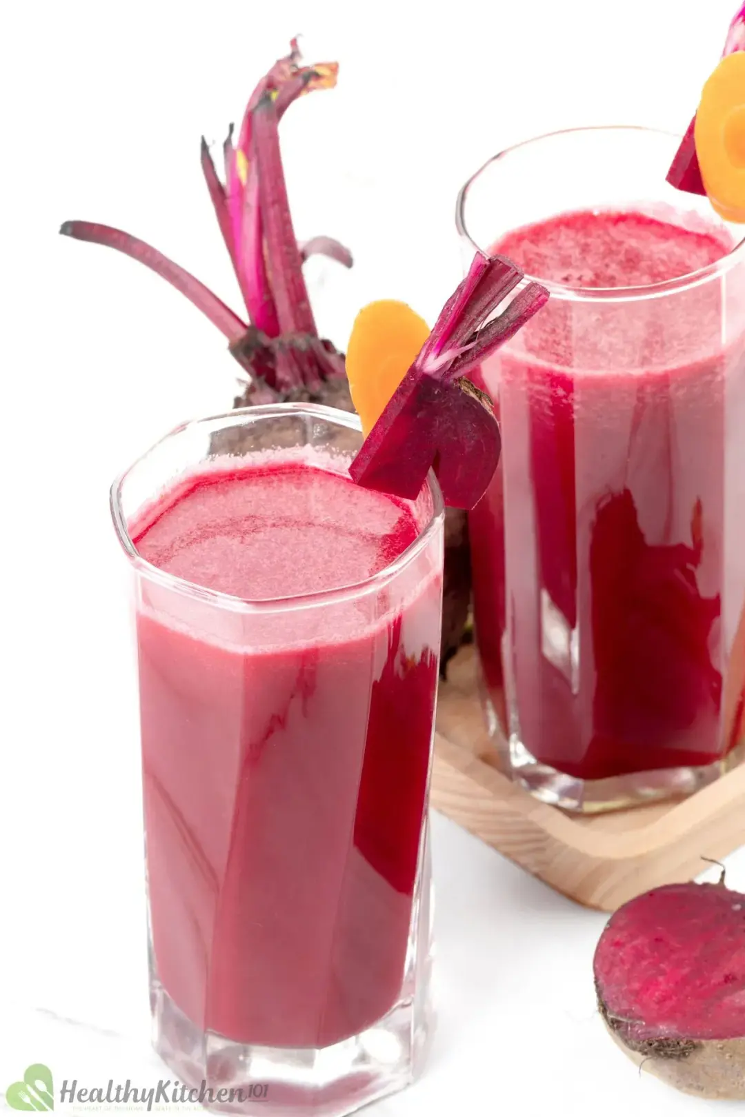 Two tall glasses of beetroot drink garnished with beetroot pieces on the rim