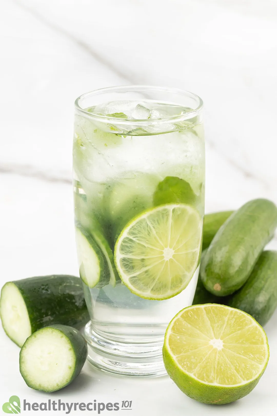 a glass of Cucumber Lime Water decorated by half lime and cucumber