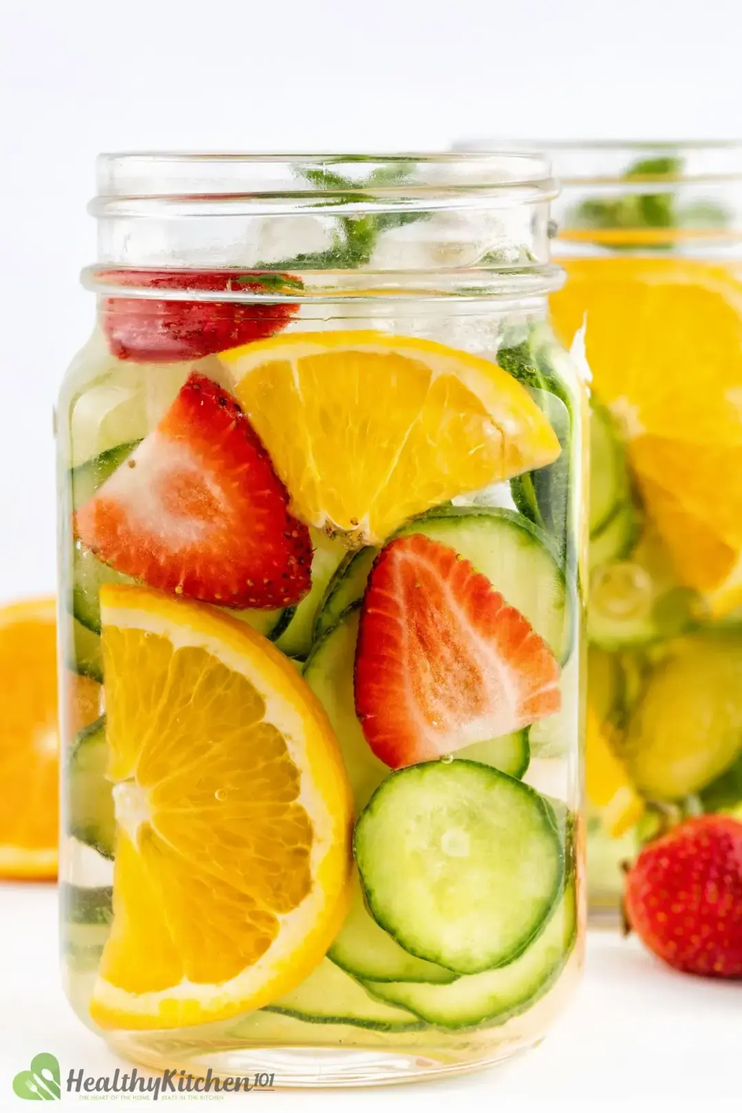 Jars of strawberries and cucumber slices in clear water