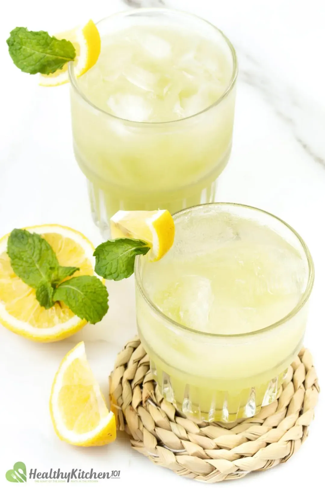 A picture of two short glasses of green grape juice taken from above