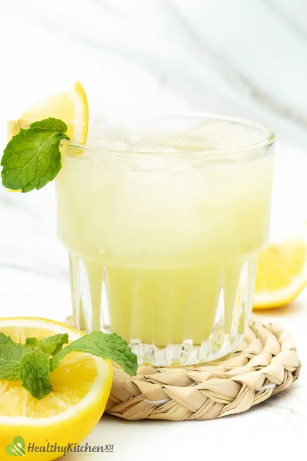 A close-up of of a short glass of green grape juice placed on a rush coaster