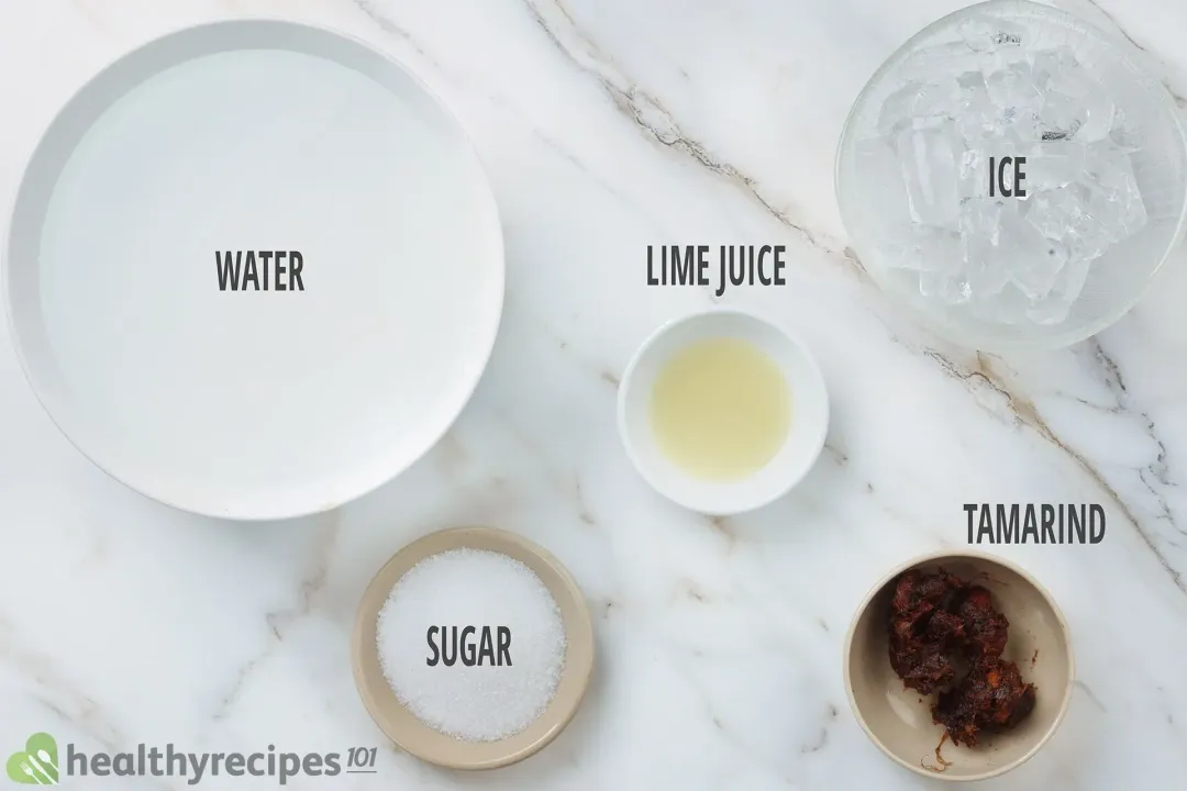 Water, lime juice, ice nuggets, tamarind seeds covered with flesh, and sugar, held in separate bowls