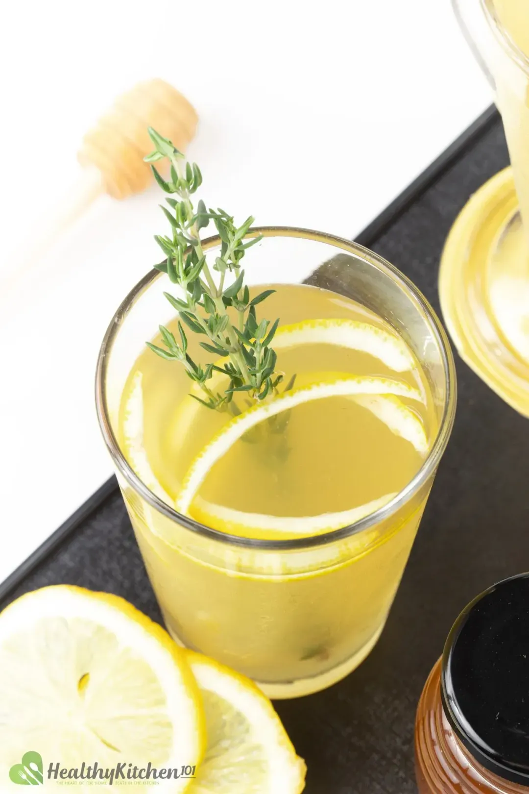 A shot from the top of a lemonade glass filled with lemon peels and thyme sprig