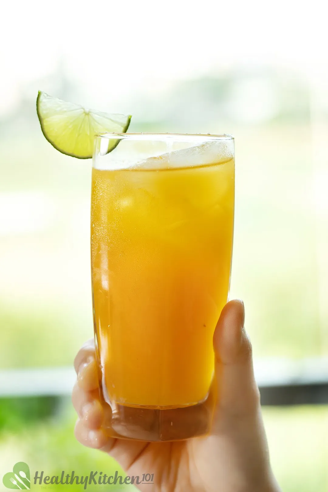 hand holds a glass of passion fruit margarita