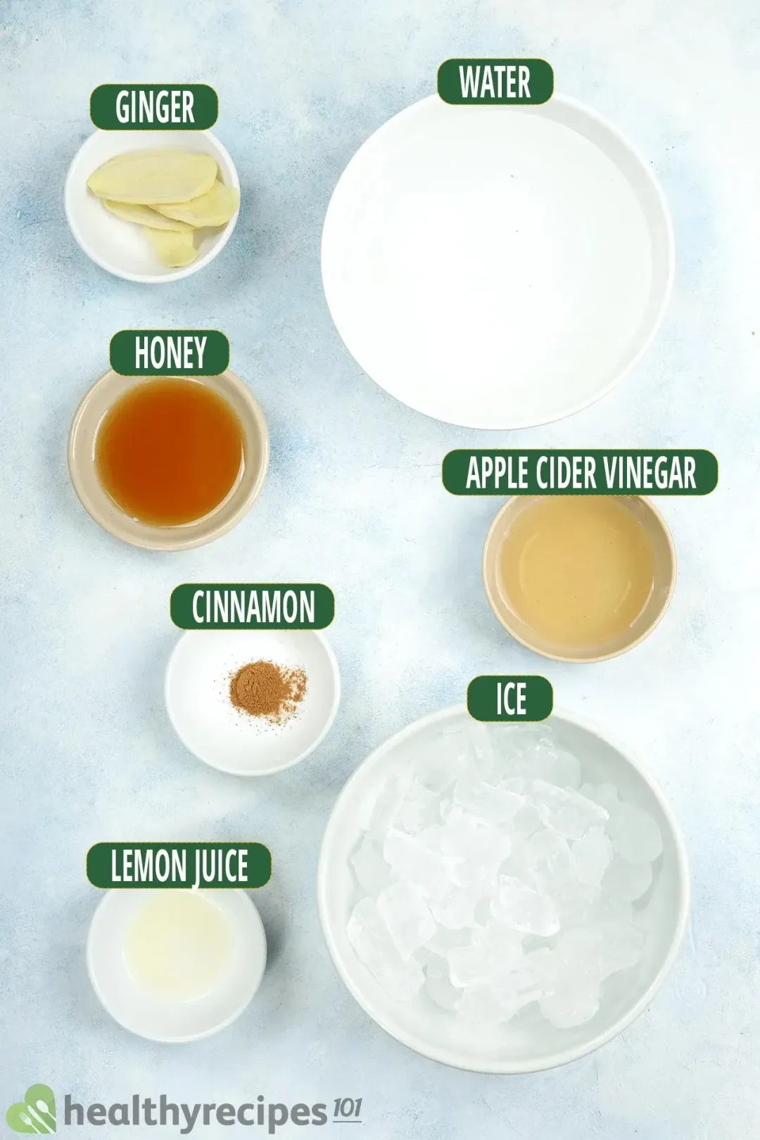 Ingredients in separate bowls: water, apple cider vinegar, ginger, honey, cinnamon, lemon juice, and ice nuggets
