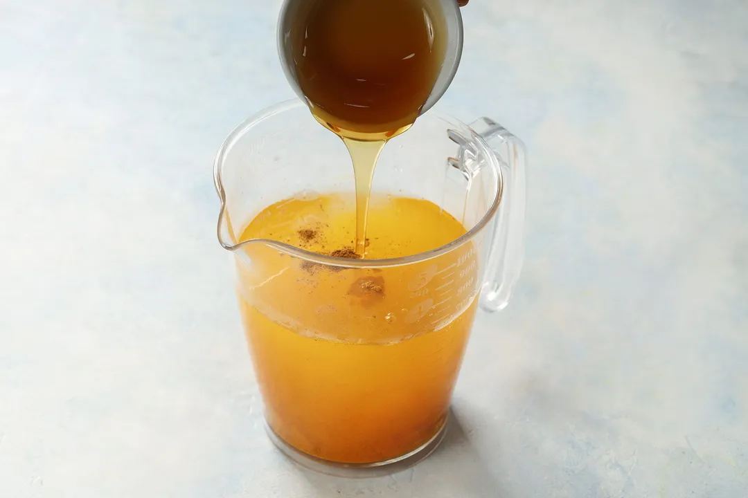 pouring honey from a bowl to a pitcher