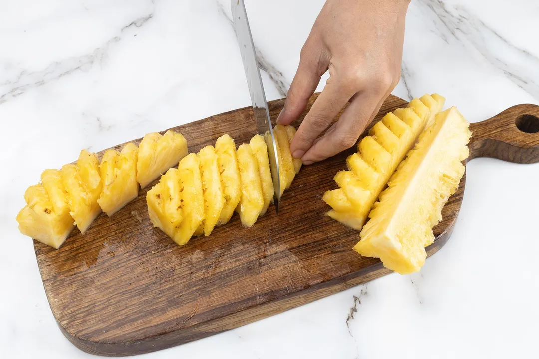 cut pineapple into chunks on a cutting board