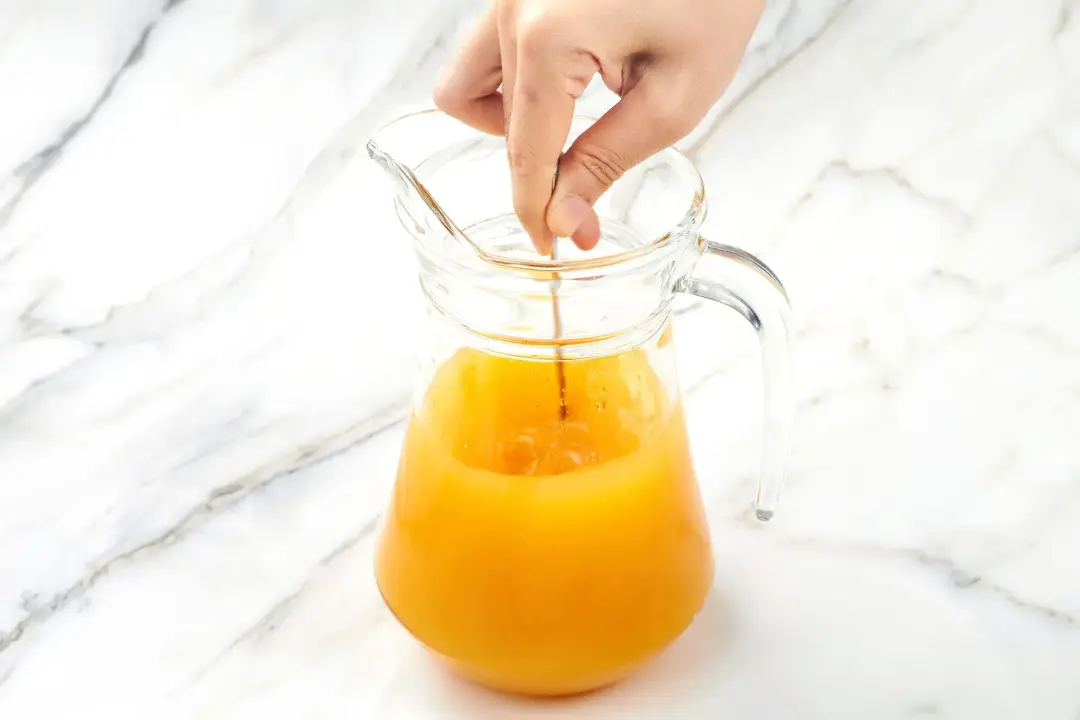 Stirring an orange juice pitcher