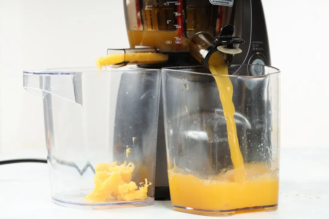 juicing orange in a juicer