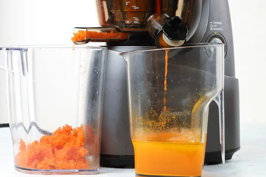 A blender making Carrot Ginger Turmeric Juice.