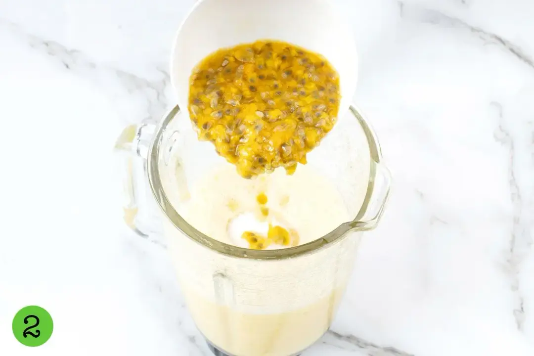 A bowl of passion fruit pulps and seeds poured into a blender