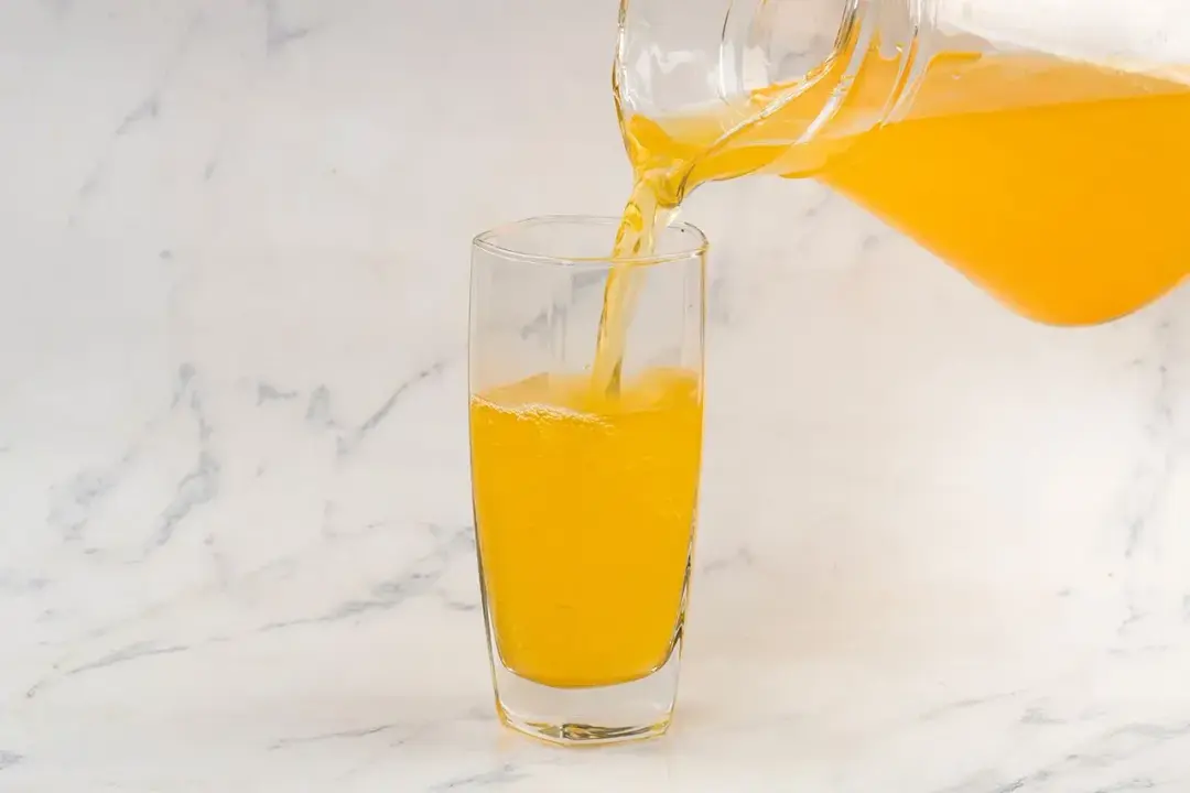a pitcher of turmeric and apple cider vinegar poured into a glass