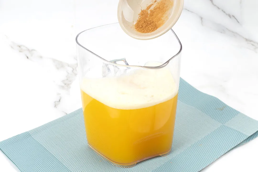 pouring star anise powder from a small bowl to a pitcher