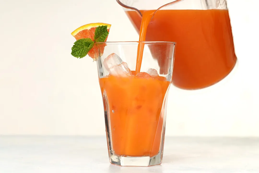 pouring juice from a pitcher into a glass