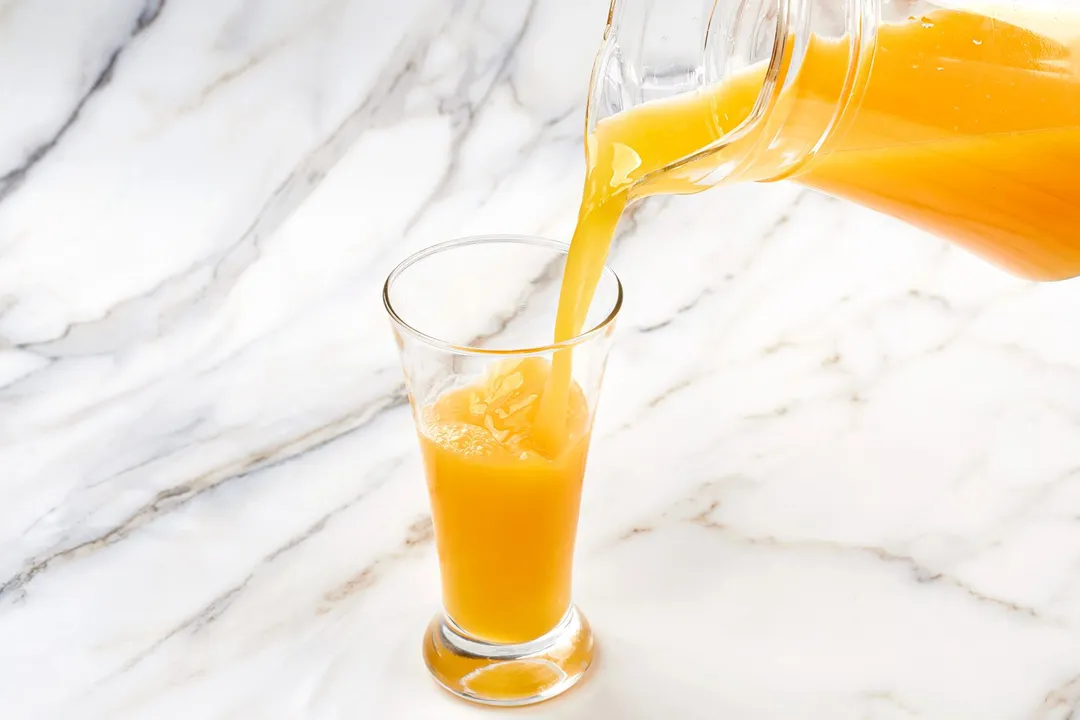 pouring juice from a pitcher into glass