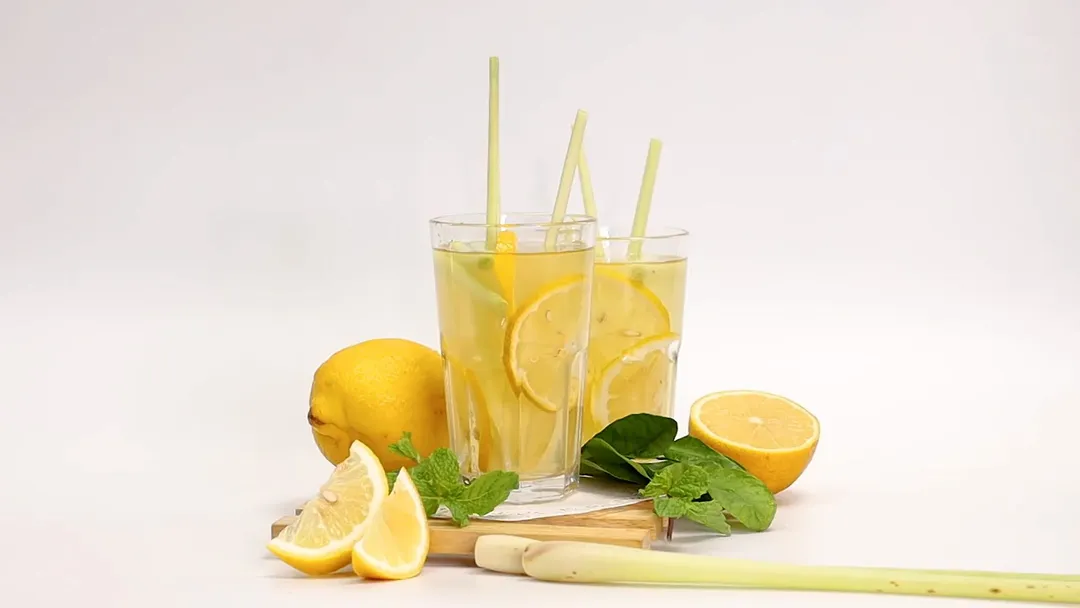 two glass of apple cider vinegar and lemon juice decorated with lemon and lemongrass