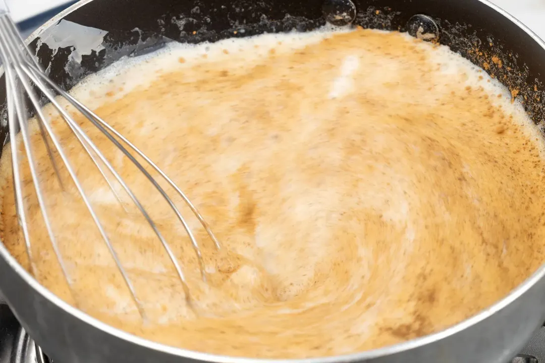 Pouring a frothy eggnog into a shot glass