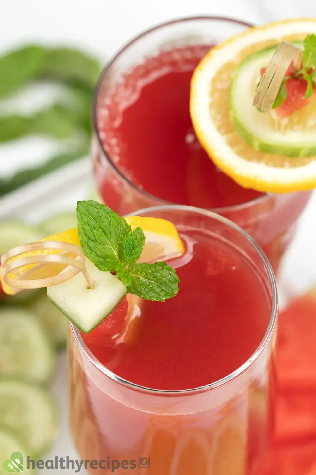 A high-angle shot of two glasses of watermelon cucumber juice decorated by garnish skewers