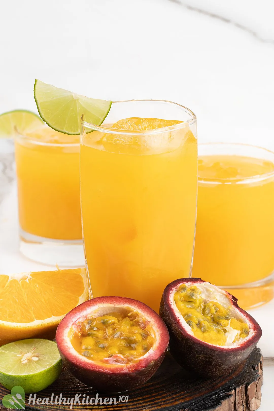 three glasses of passion fruit margarita decorated with half passion fruit, lime, orange