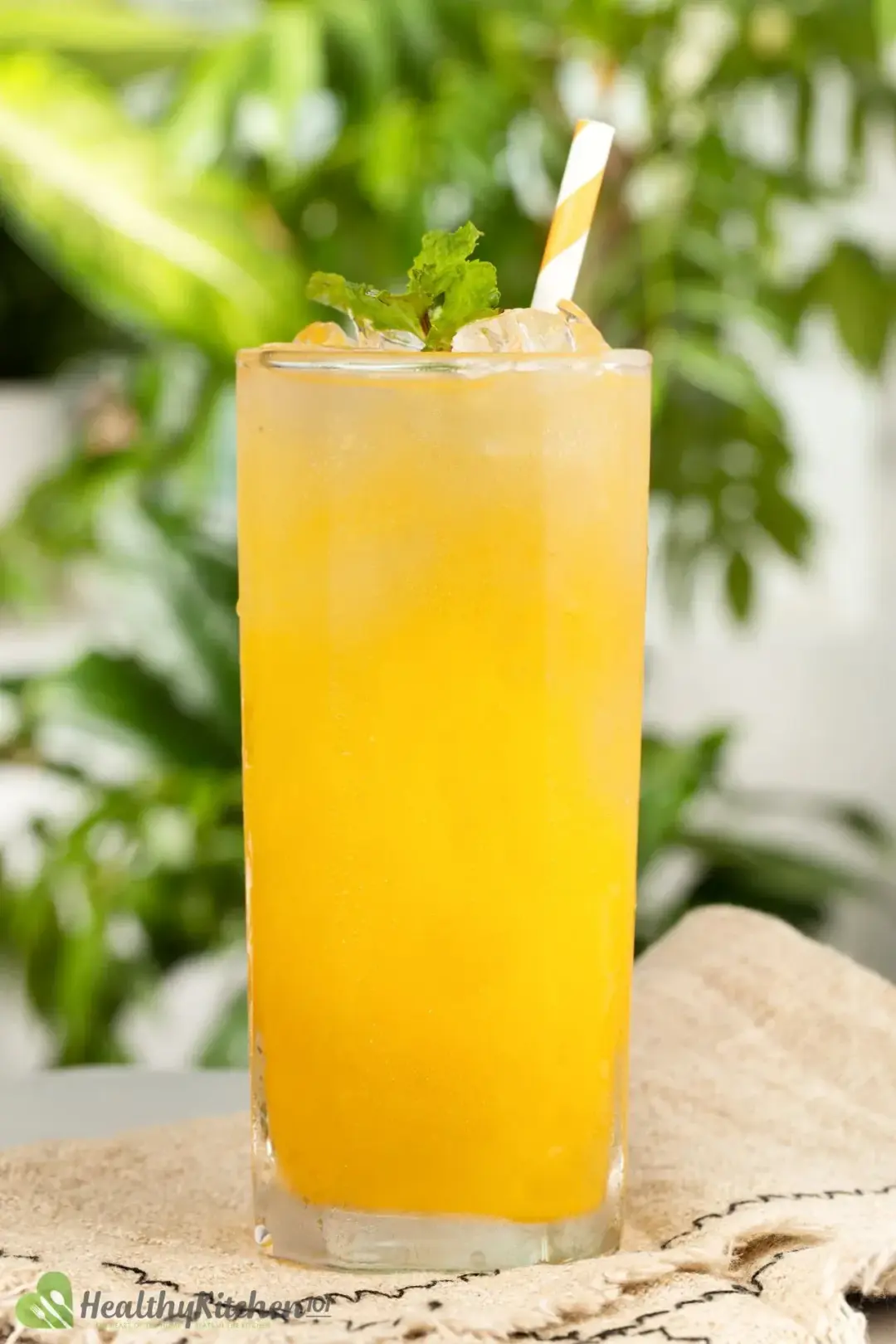 A tall glass of orange juice and ginger ale cocktail on a kitchen cloth