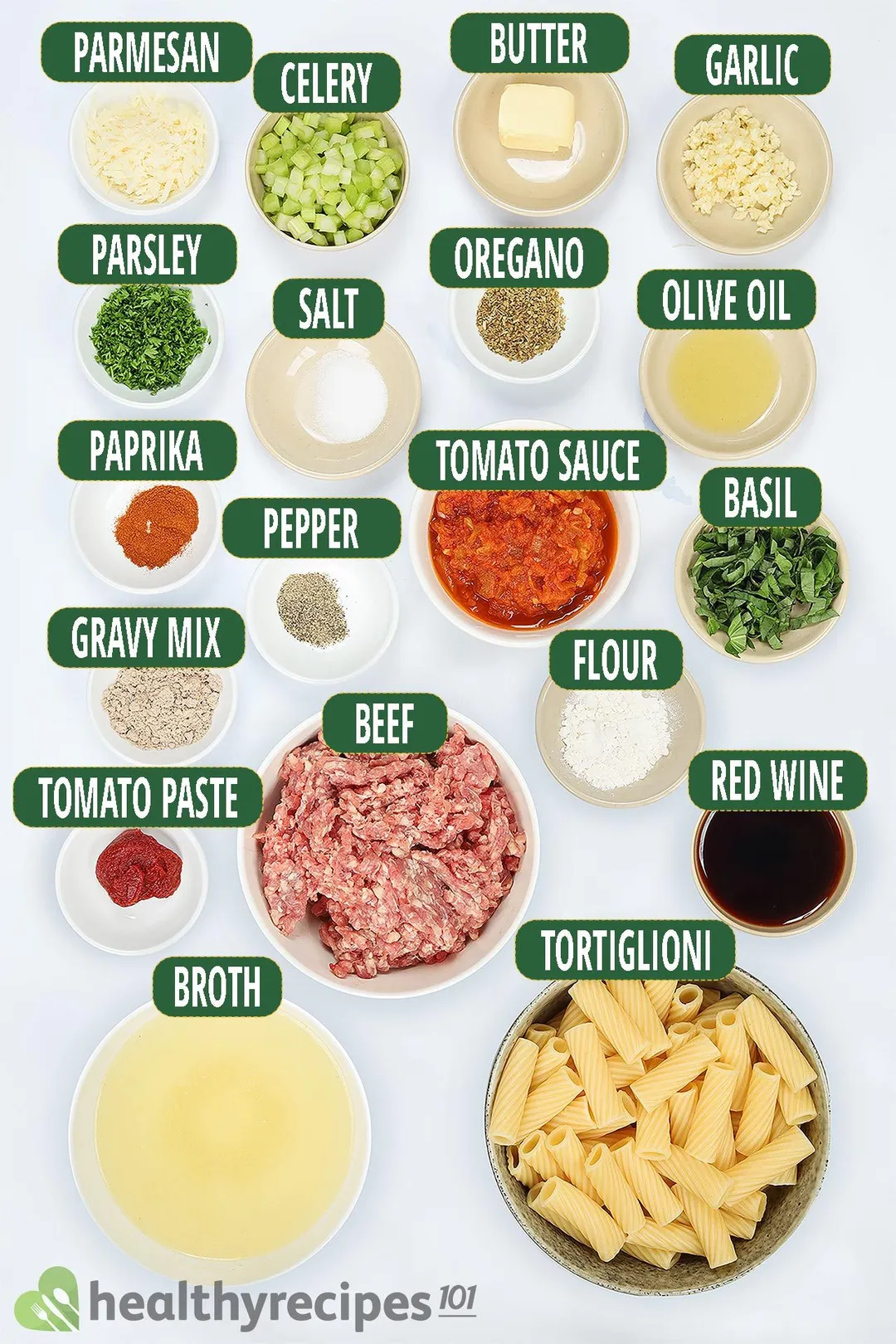 ingredients for Pasta Bolognese, including bowls of tortiglioni, raw ground beef, tomato sauce, chopped herbs, and other condiments.