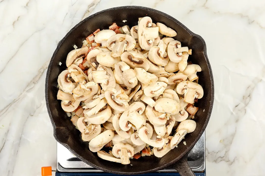 mushroom cooking in a cast iron skillet