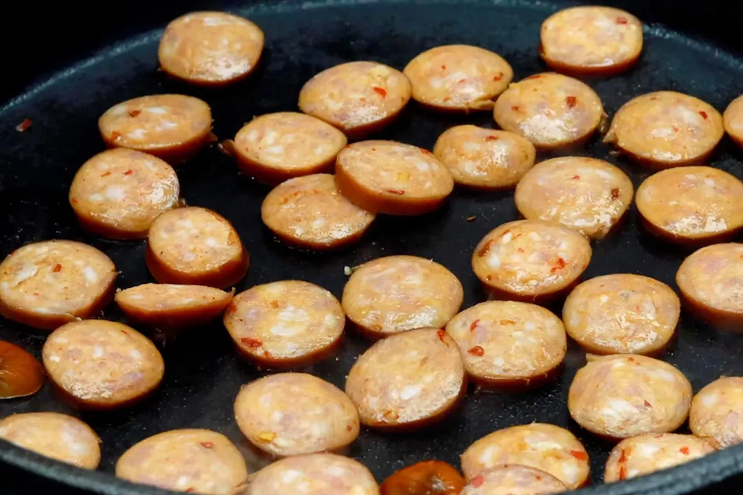 slices sausage cooking in a skillet