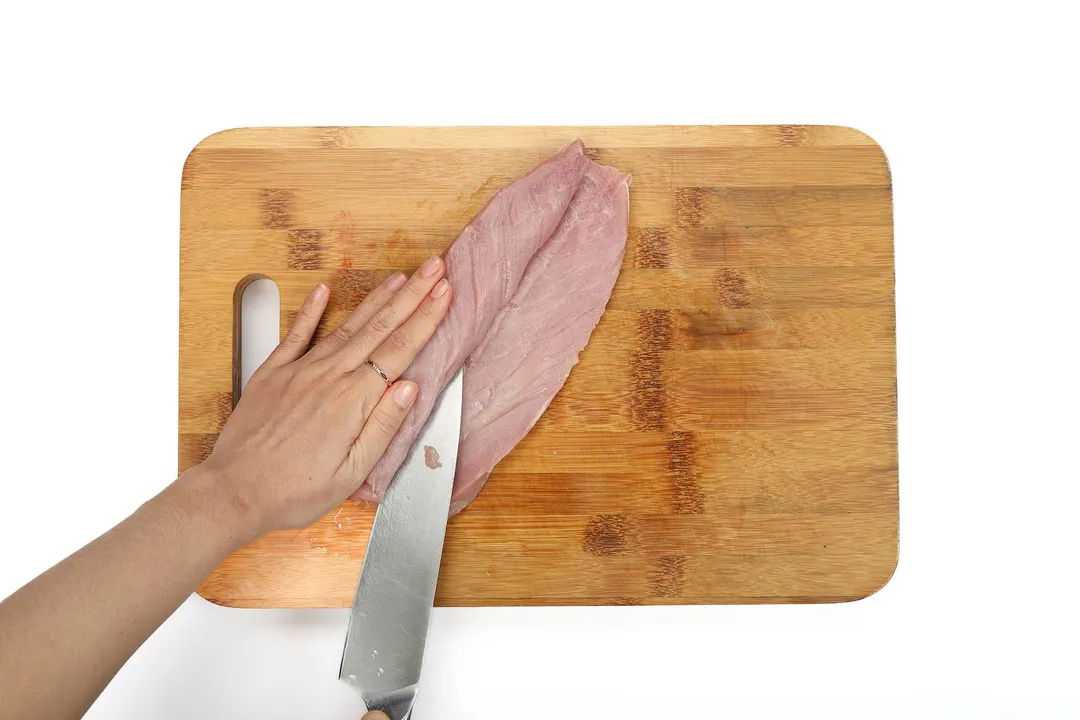 slice the center of pork loin by a knife on cutting board