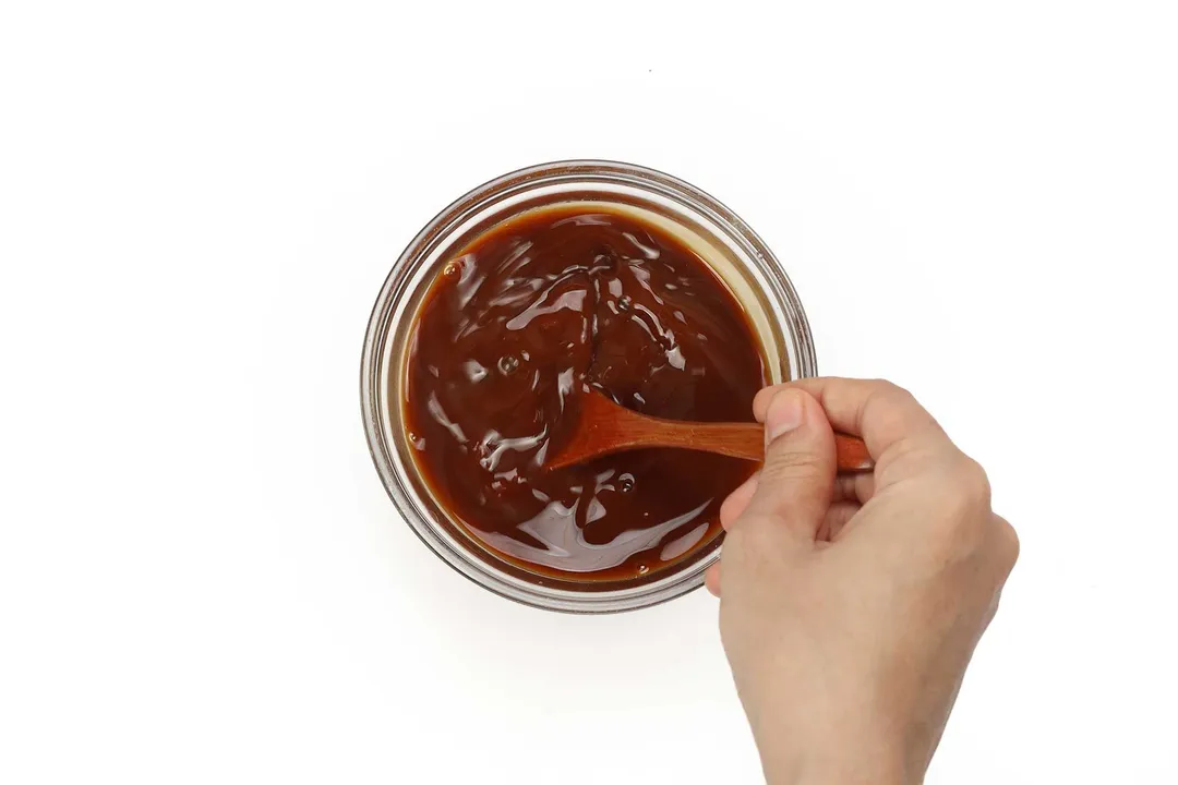 whisking sauce in a glass bowl