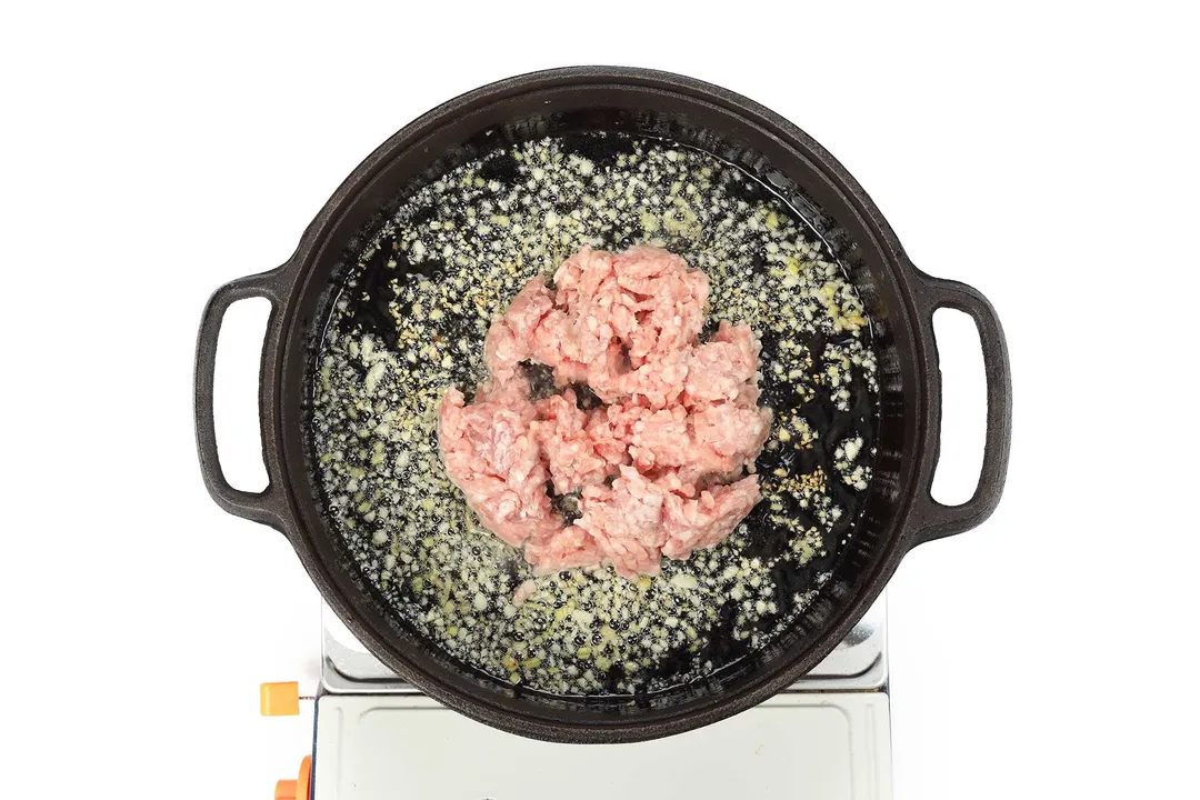 cooking ground pork in a skillet with oil