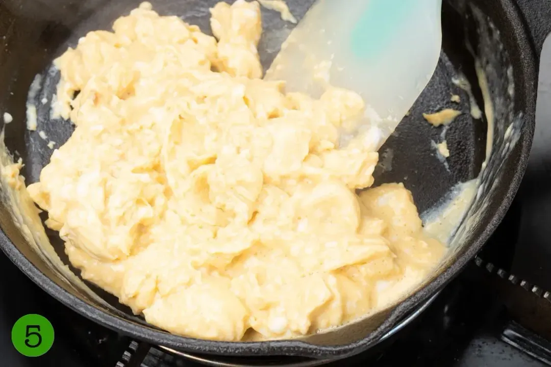 Eggs scrambled inside a cast iron skillet